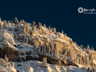 Winter Peak Sunrise A lonely alpine high valley captured in the evening sun. The summit of Piz Dolf reaches 2998 meters above sea level. In the shadow of the spectacular mountain flank still lies the snow of last winter. The ice-cold melt water flows in a torrent to the next waterfall where it thunders down into the valley.